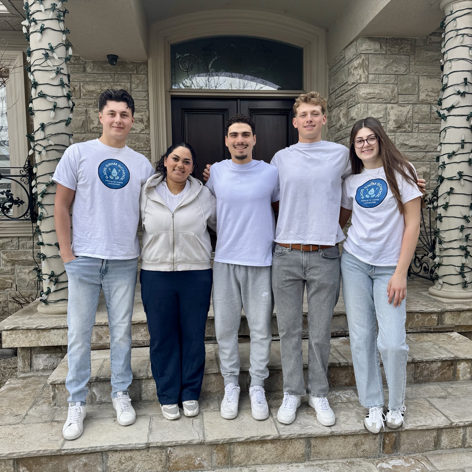 Five Ilios team members together in their swim school shirts