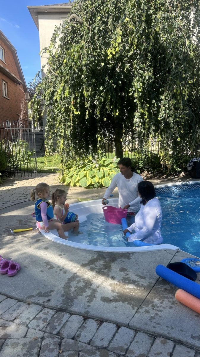 Swimmers learning with Ilios instructors in a backyard pool