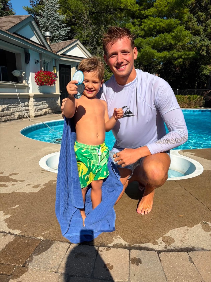 An Ilios instructor celebrating a young swimmer’s achievement